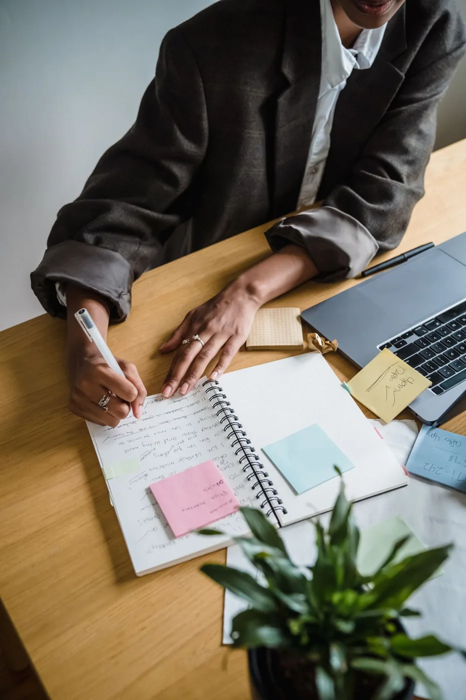 Woman writing notes in a notebook at a desk