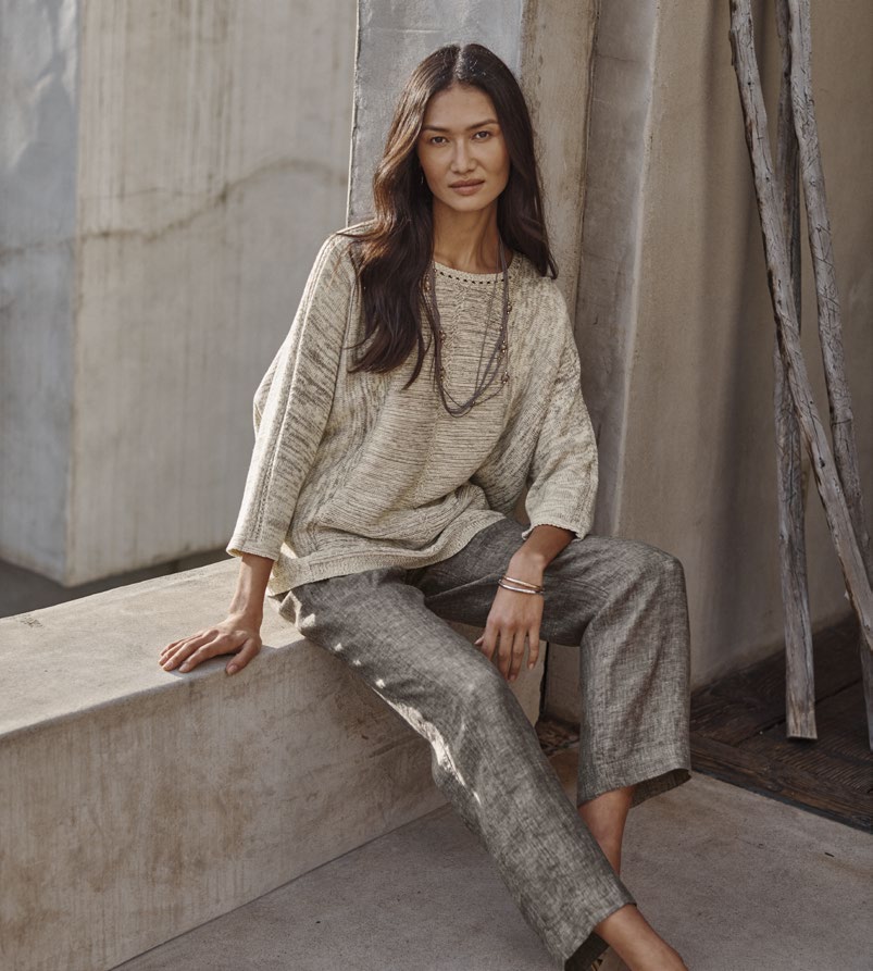 Official Pure Jill photograph: woman seated in a textured neutral top and relaxed trousers