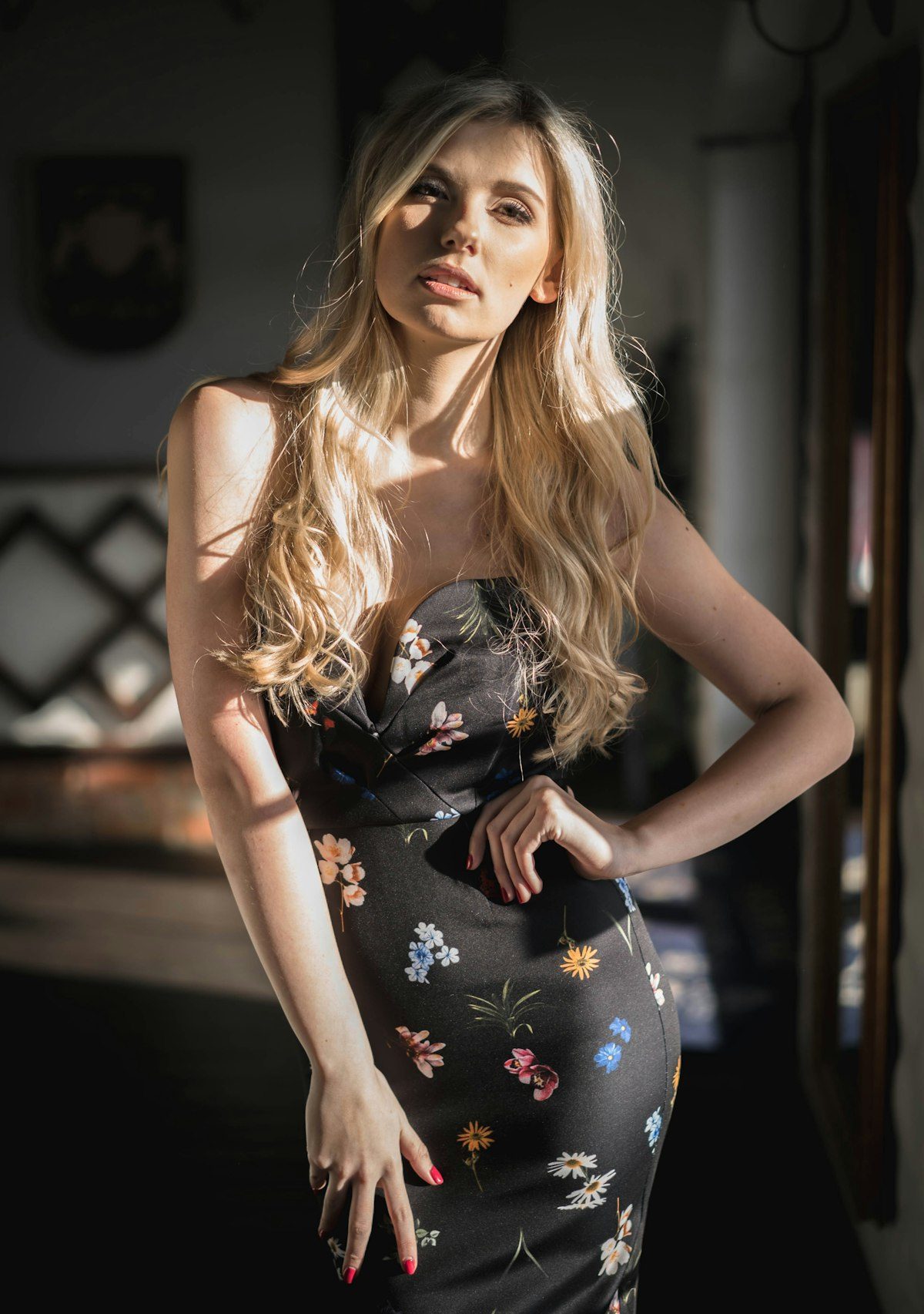 Woman wearing a dark floral sleeveless dress indoors.