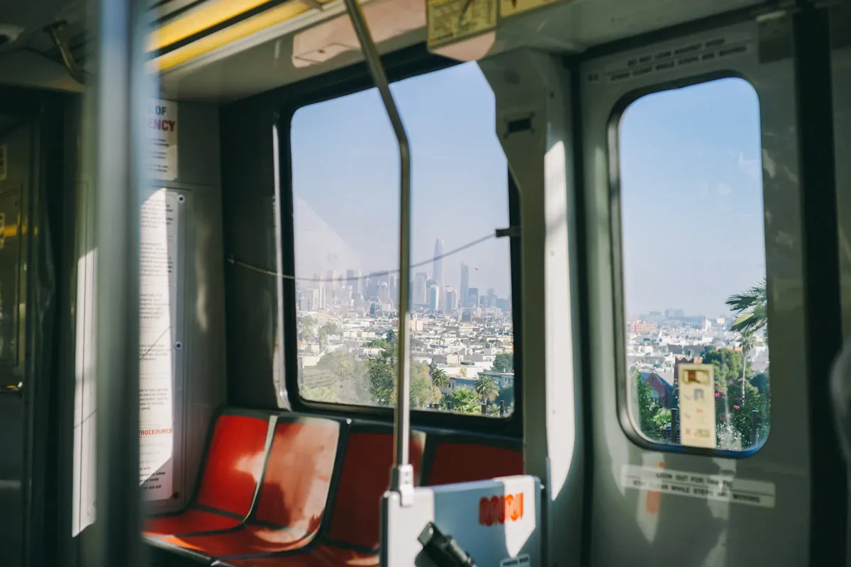 Red and grey passenger seats beneath wide train windows