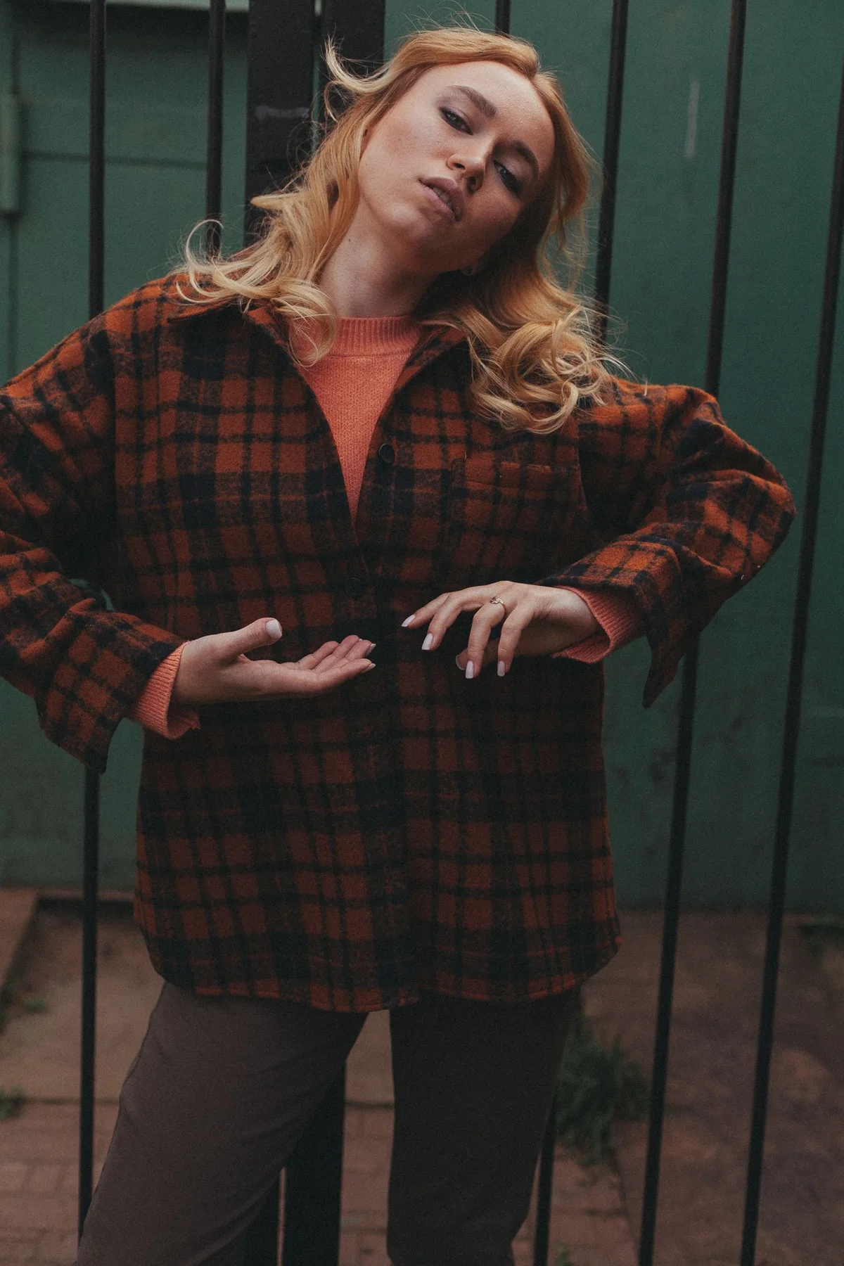 Woman wearing a red and black checked shirt outside a building.