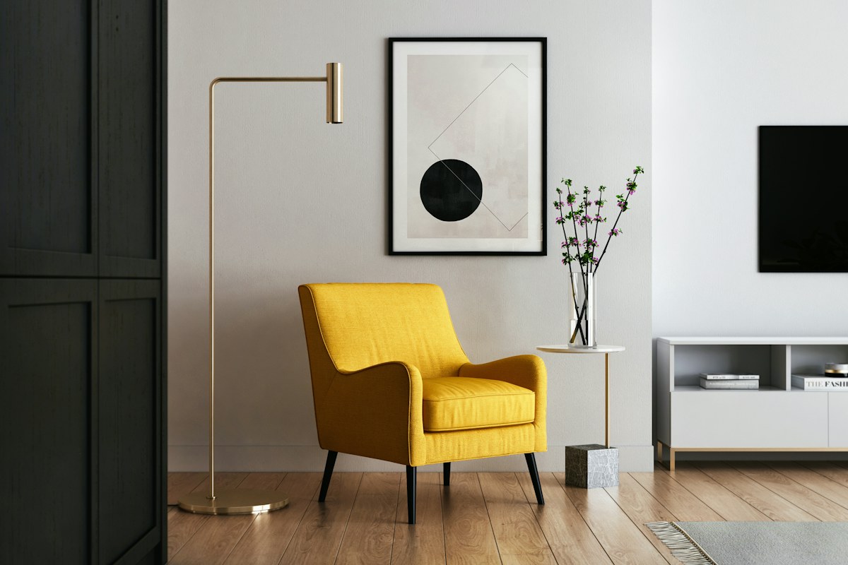 A yellow upholstered chair in a grey room.