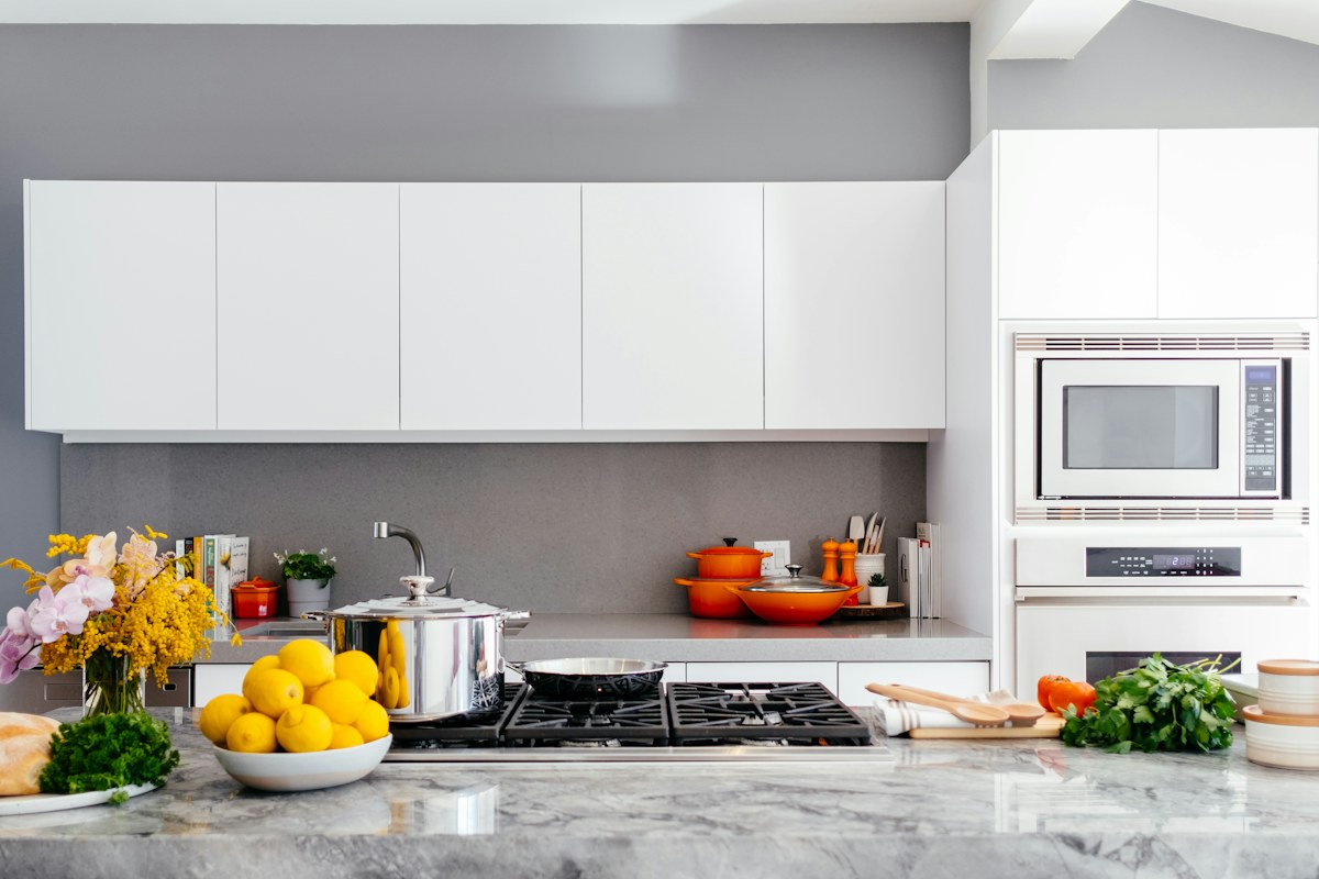A bright kitchen with white cabinets and a pale island countertop.